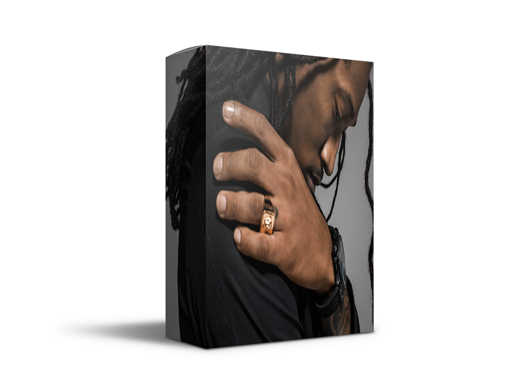 Close-up of a man with dreadlocks wearing a gold ring, looking down in deep thought, on a stylish black and gray product box.