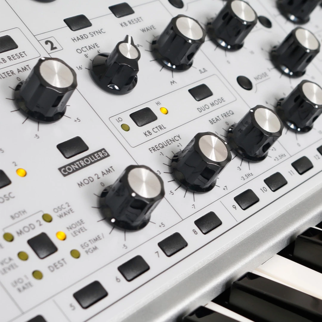 Close-up of analog synthesizer control panel with knobs and switches for sound modulation